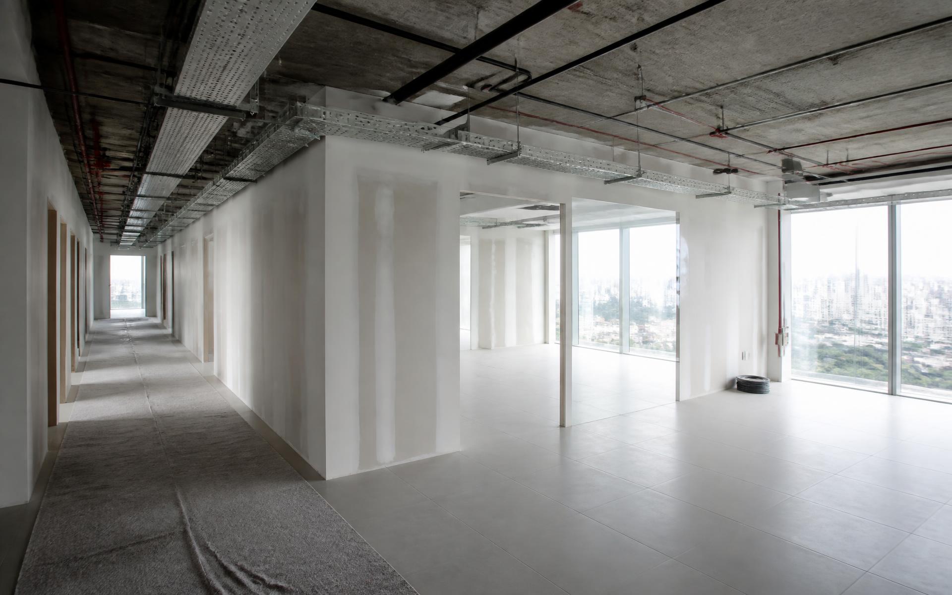 Pavimento corporativo em obra com divisórias de drywall e infraestrutura aparente