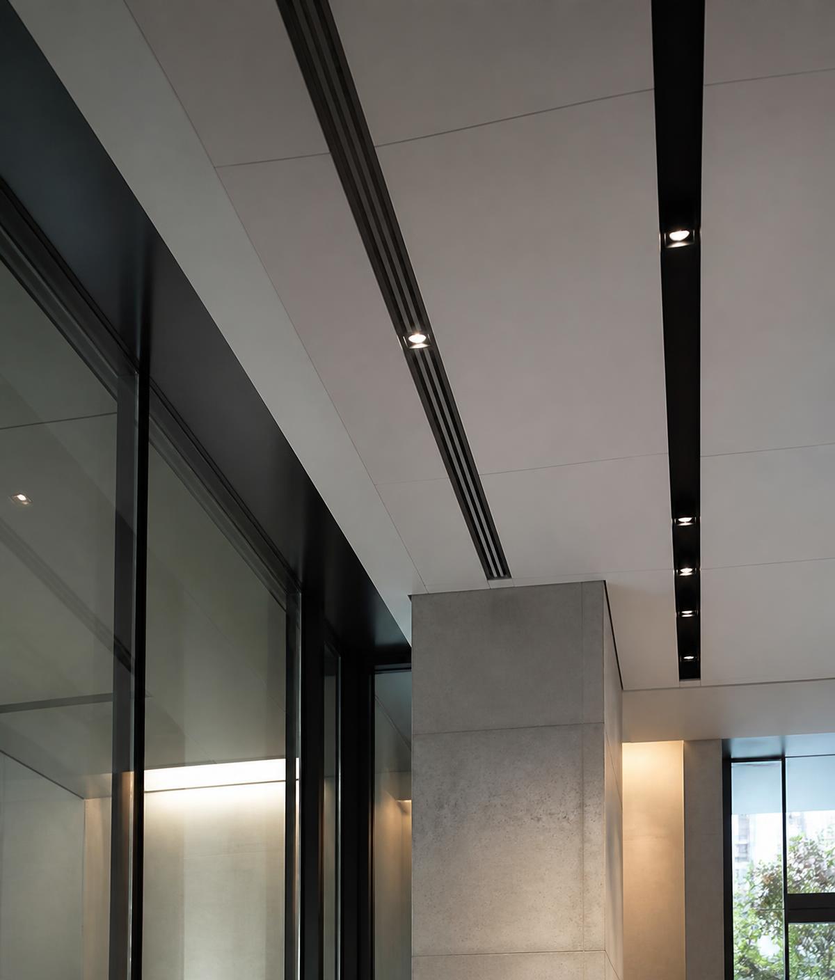 Detalhe de forro técnico e iluminação linear em edifício corporativo
